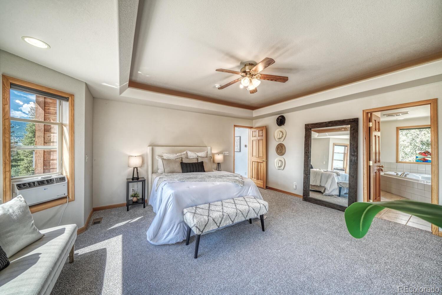 50 Ridge Lane Bailey, CO 80421 - Photo 14 of 37 a spacious bedroom with a bed and a chandelier