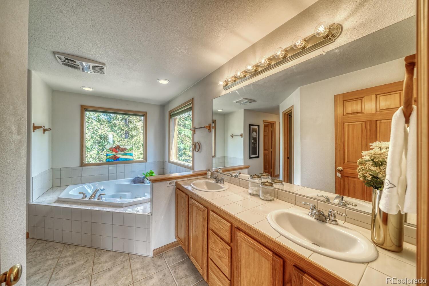 50 Ridge Lane Bailey, CO 80421 - Photo 16 of 37 a bathroom with a granite countertop tub sink and mirror