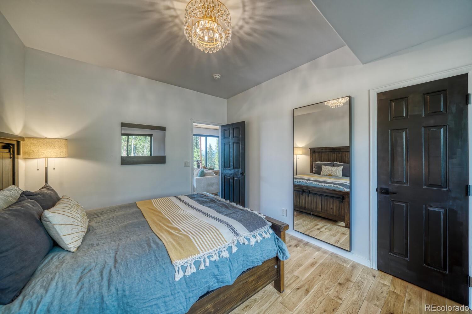 50 Ridge Lane Bailey, CO 80421 - Photo 19 of 37 a bedroom with a bed and a chandelier