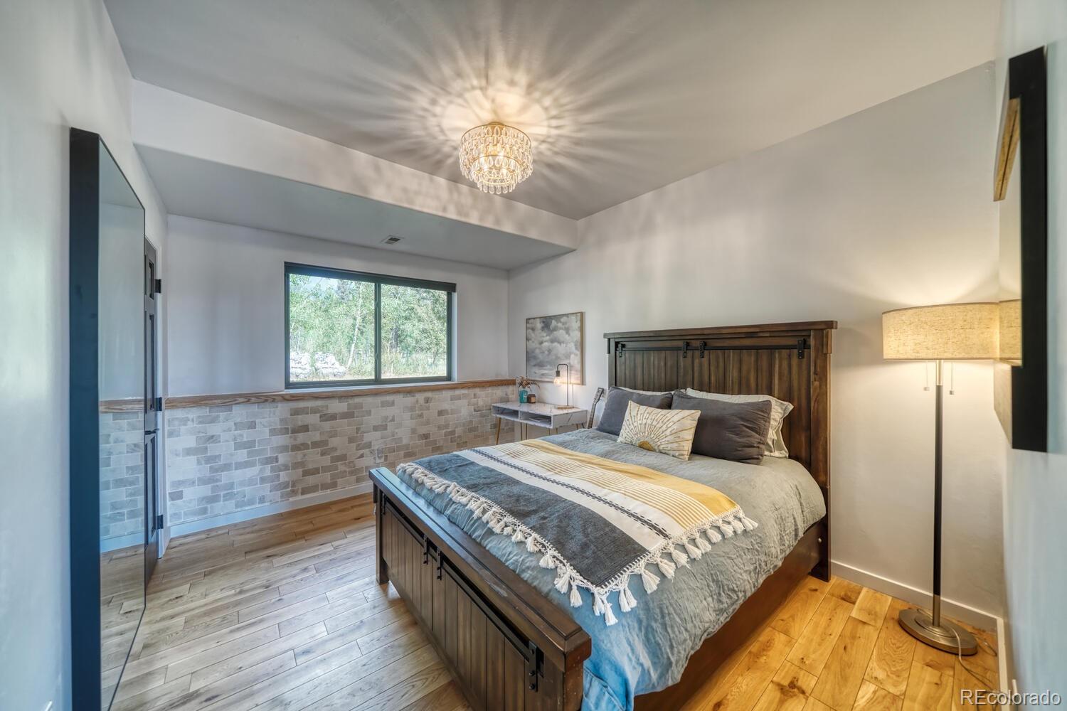 50 Ridge Lane Bailey, CO 80421 - Photo 20 of 37 a bedroom with a bed and a chandelier