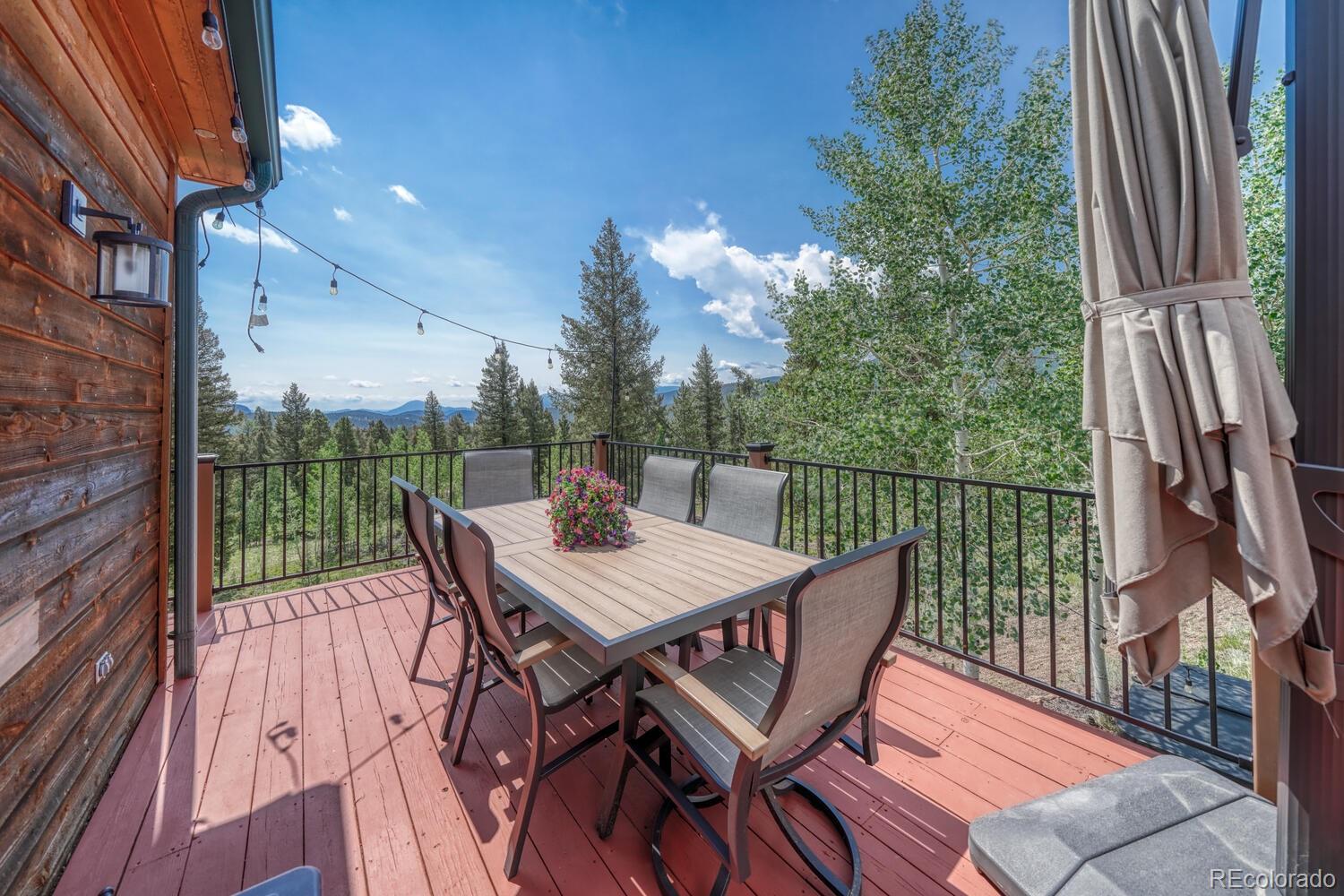 50 Ridge Lane Bailey, CO 80421 - Photo 5 of 37 a view of a roof deck with table and chairs with wooden floor and fence