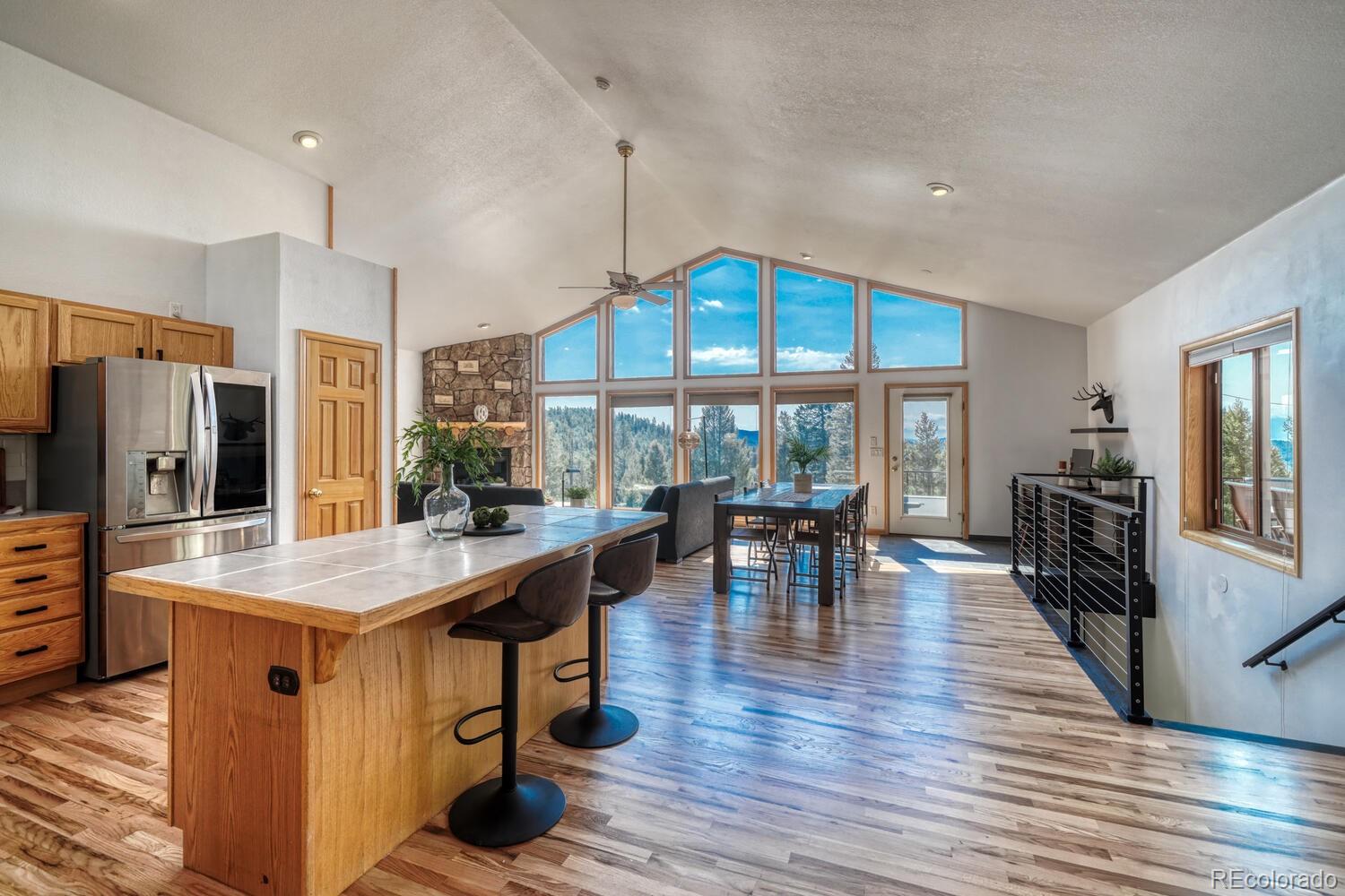 50 Ridge Lane Bailey, CO 80421 - Photo 8 of 37 a dining hall with stainless steel appliances granite countertop a stove oven a dining table and chairs with wooden floor