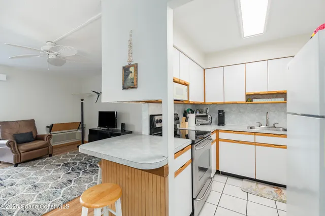 a kitchen with a refrigerator a stove top oven a sink dishwasher and dining table with wooden floor