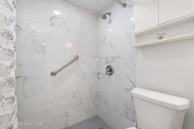 a bathroom with a shower a toilet and sink