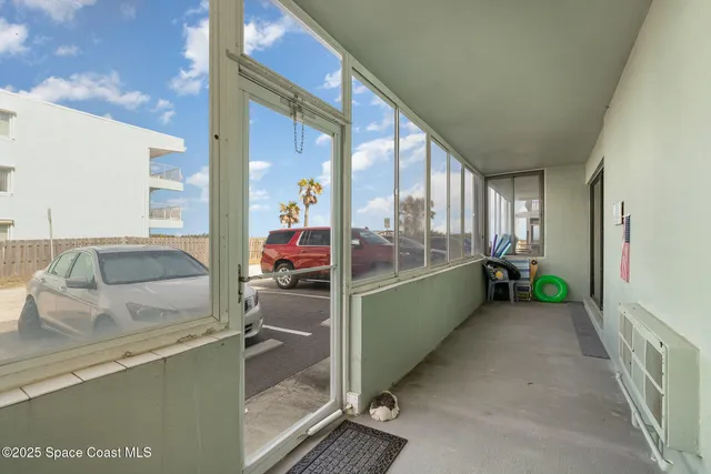 a front view of a house with a large tree