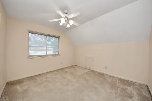 a view of a room with a ceiling fan and a window
