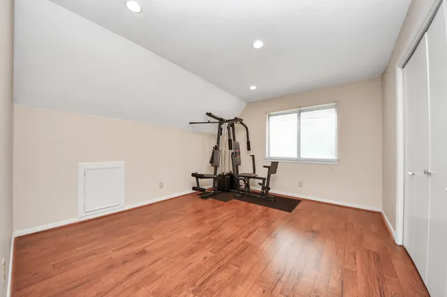 an empty room with windows and chandelier fan