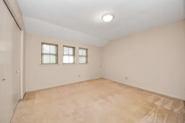 a view of a room with wooden floor air conditioner and windows