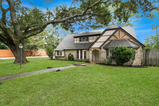 a front view of a house with a yard and trees