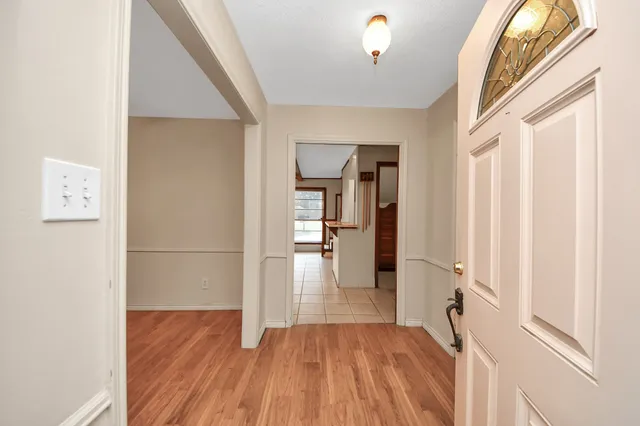 a view of a hallway with wooden floor and staircase