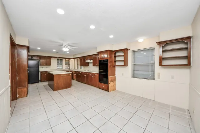 a large kitchen with stainless steel appliances a refrigerator and a stove top oven