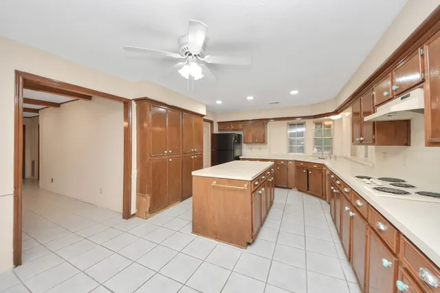 a large kitchen with stainless steel appliances granite countertop a sink and a refrigerator