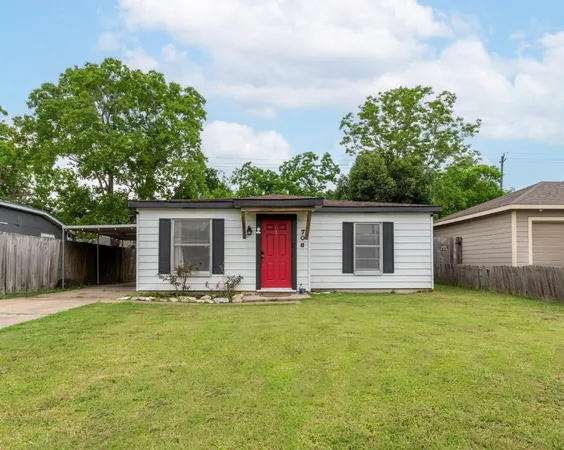 a front view of house with yard and trees in the background