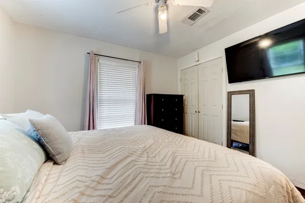 a bedroom with a bed and a flat screen tv