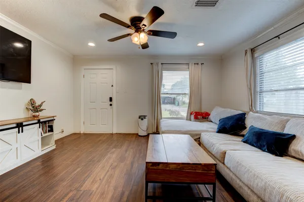 a living room with a bed furniture and a flat screen tv