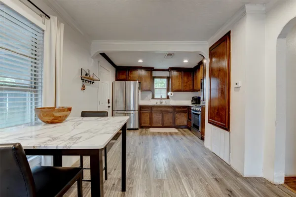 a kitchen with a table chairs refrigerator and cabinets