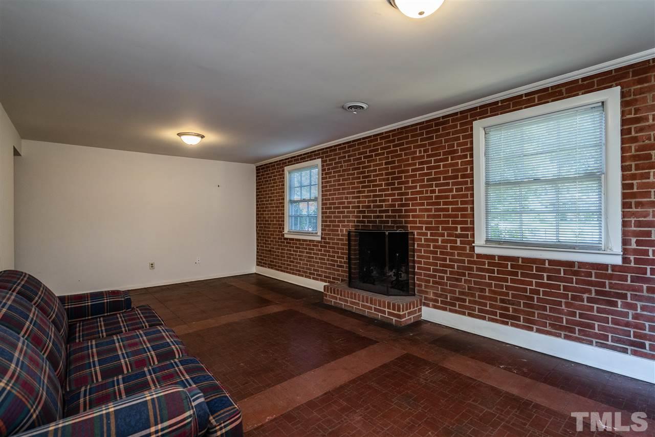 4708 Latimer Road Raleigh, NC 27609 - Photo 14 of 22 a view of an empty room with a fireplace and a window