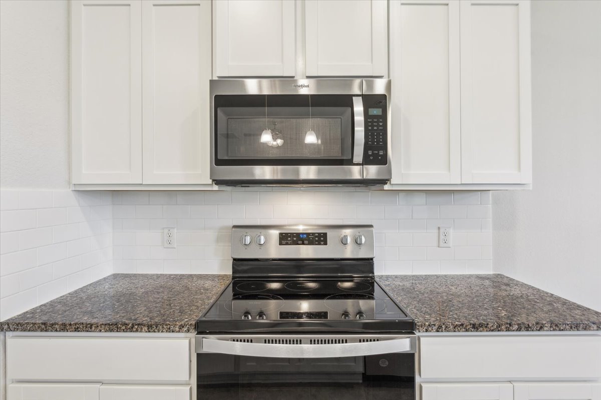 5830 Copano Road Belton, TX 76513 - Photo 15 of 34 Kitchen with tasteful backsplash, white cabinets, and stainless steel appliances
