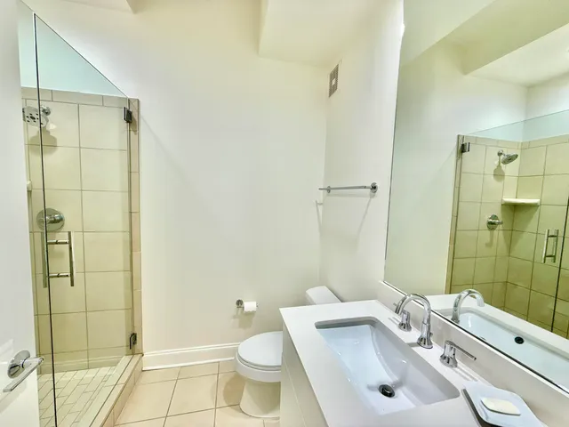 a bathroom with a granite countertop sink toilet and shower