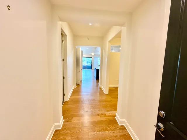 a view of a hallway with wooden floor
