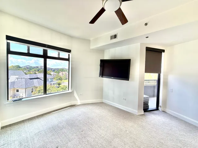 a view of an empty room with a window and a flat screen tv