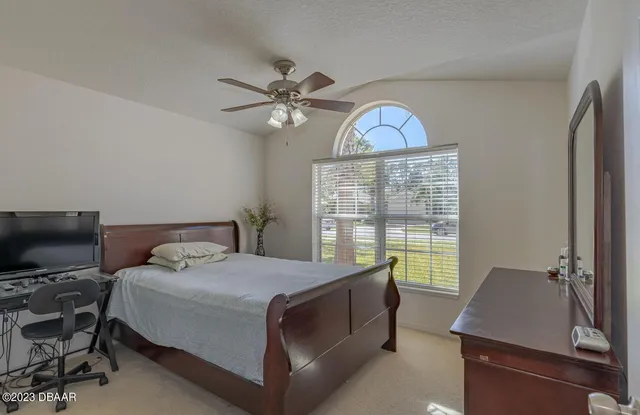a bedroom with a bed window and a flat screen tv