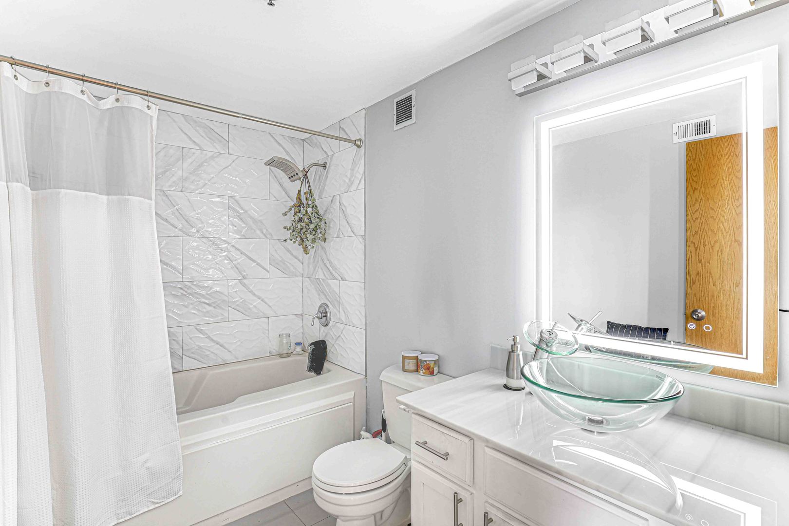 1250 West Van Buren Street, Unit 515 Chicago, IL 60607 - Photo 14 of 17 a bathroom with a granite countertop sink toilet and shower