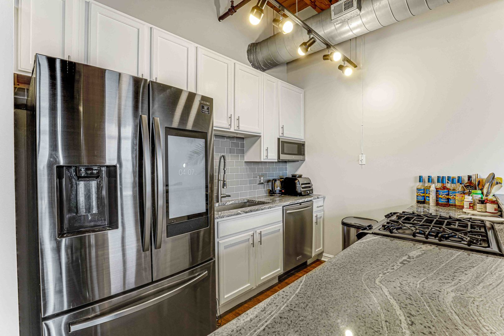 1250 West Van Buren Street, Unit 515 Chicago, IL 60607 - Photo 3 of 17 a kitchen with stainless steel appliances a refrigerator sink and stove