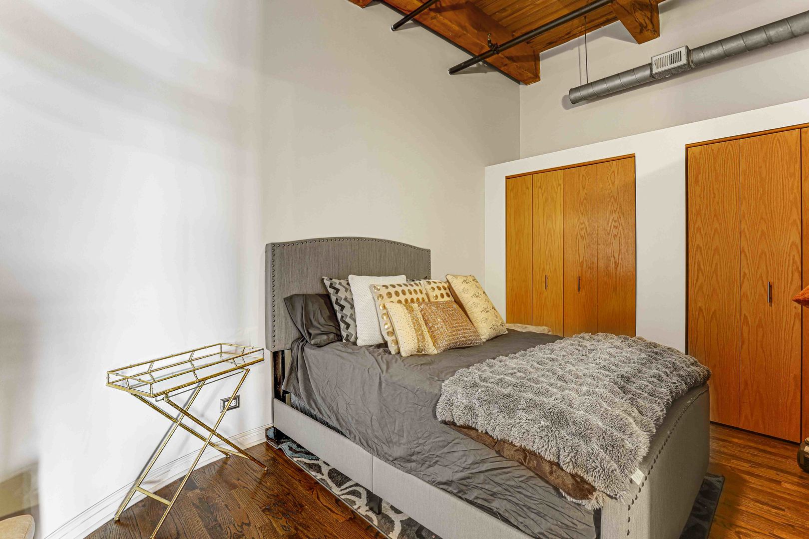 1250 West Van Buren Street, Unit 515 Chicago, IL 60607 - Photo 9 of 17 a bedroom with a bed and wooden floor