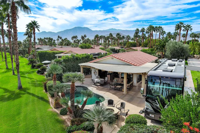 a patio with sofas fire pit table and chairs