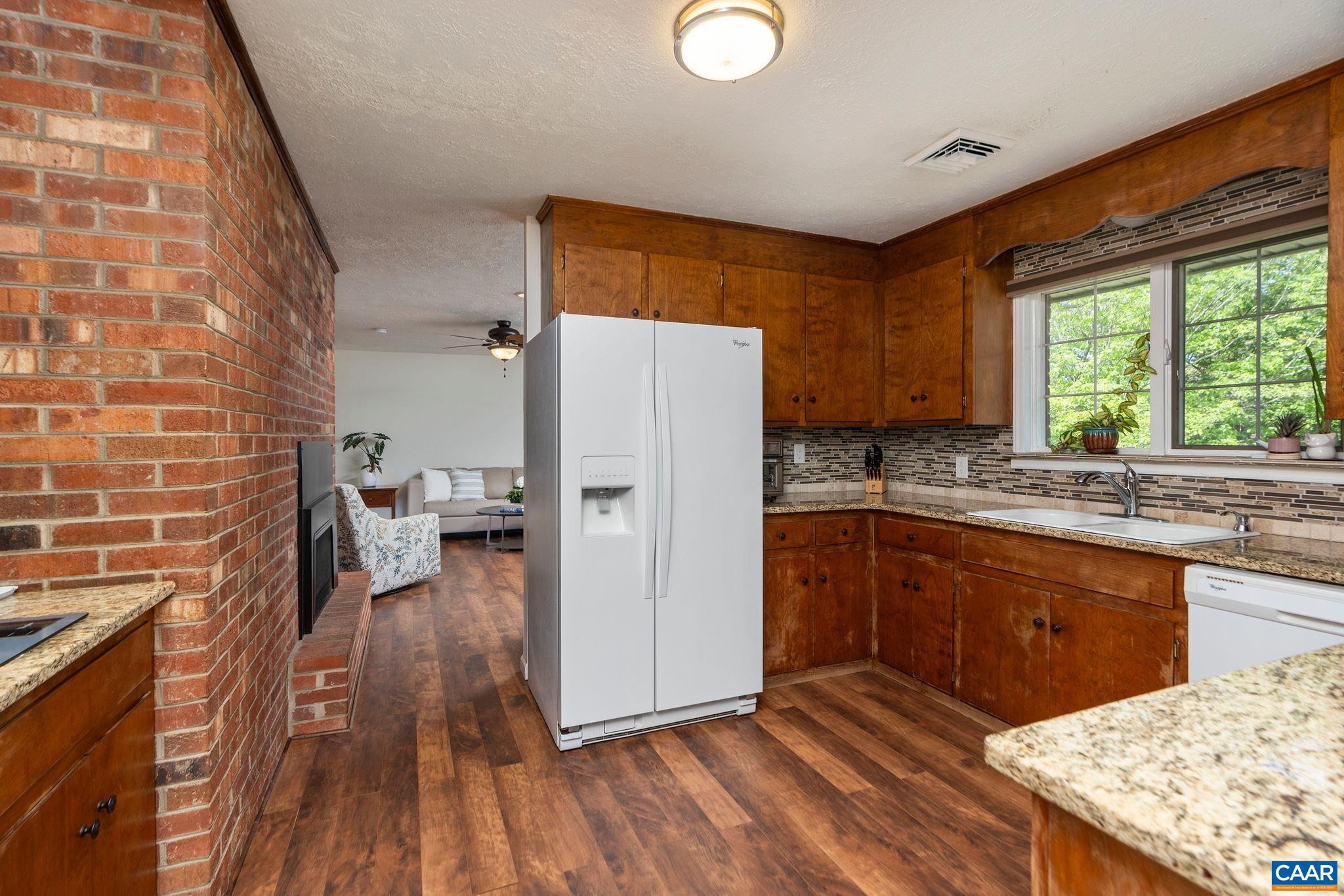 77 Sunset Drive Arrington, VA 22922 - Photo 9 of 35 a kitchen with granite countertop a refrigerator a sink dishwasher a stove and white countertops with wooden floor