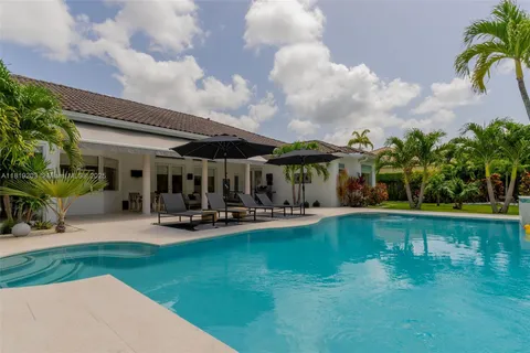 a view of a swimming pool with lounge chairs in patio
