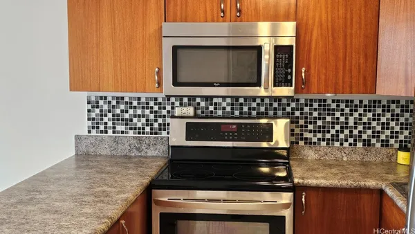 a kitchen with granite countertop a stove and a microwave