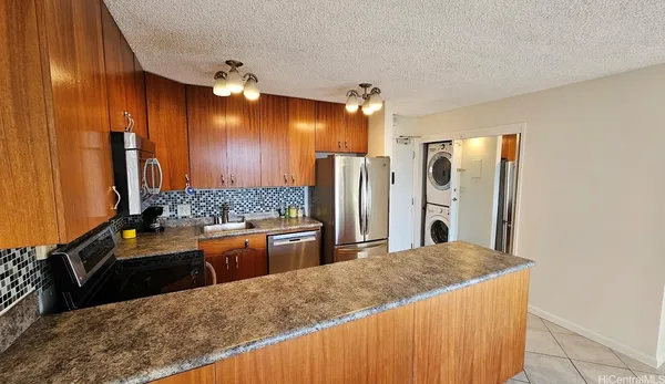 a kitchen with stainless steel appliances kitchen island granite countertop a refrigerator and stove