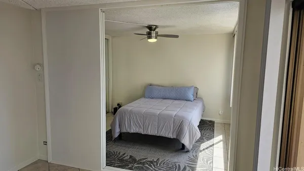 a bedroom with a bed and a ceiling fan