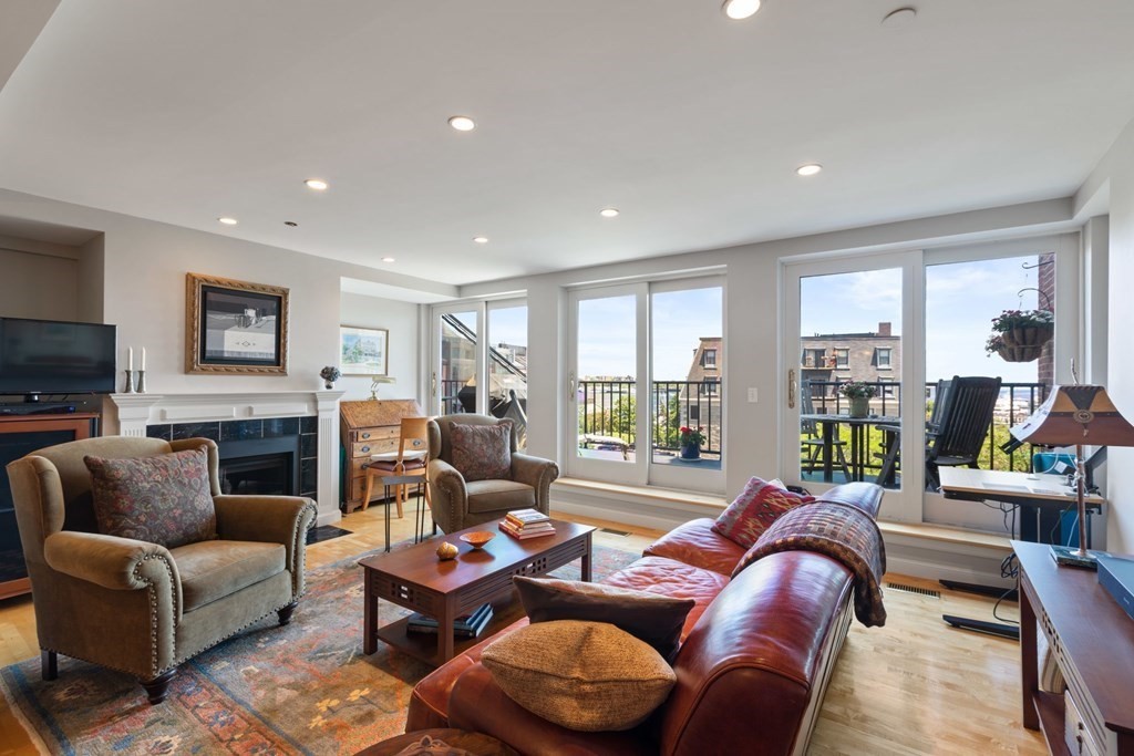 a living room with furniture fireplace and a large window