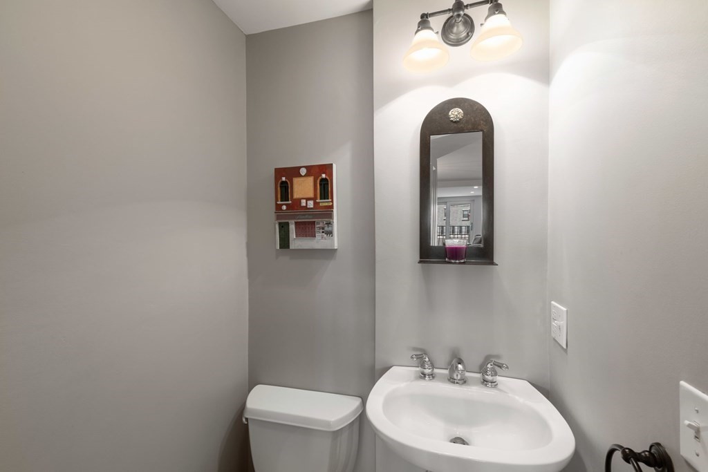 220 Commercial Street, Unit 5A Boston, MA 02109 - Photo 28 of 40 a bathroom with a sink toilet and mirror