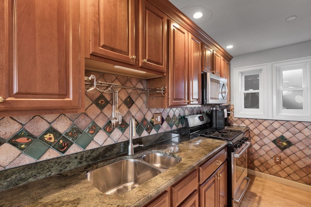 220 Commercial Street, Unit 5A Boston, MA 02109 - Photo 7 of 40 a kitchen with granite countertop a sink a stove and cabinets