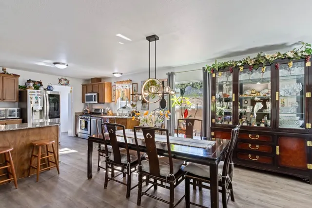 a view of a dining room and livingroom with furniture wooden floor a chandelier