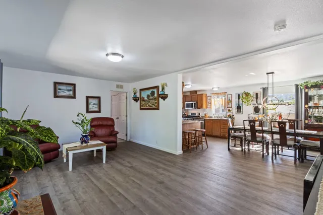 a living room with furniture a wooden floor and next to a window