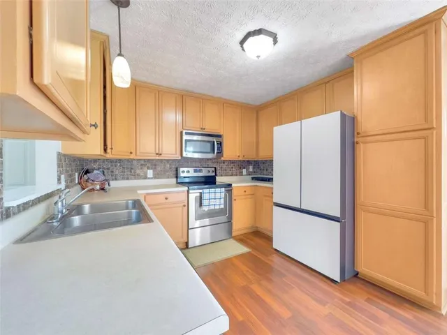 a kitchen with refrigerator a microwave and sink
