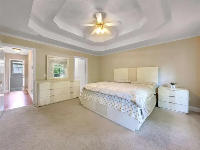 a spacious bedroom with a bed and a chandelier