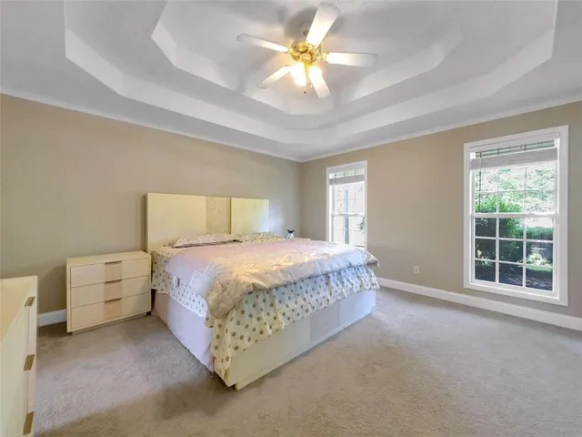 a spacious bedroom with a bed and a chandelier