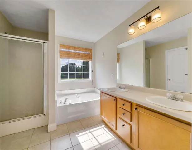 a spacious bathroom with a granite countertop sink mirror and a bathtub