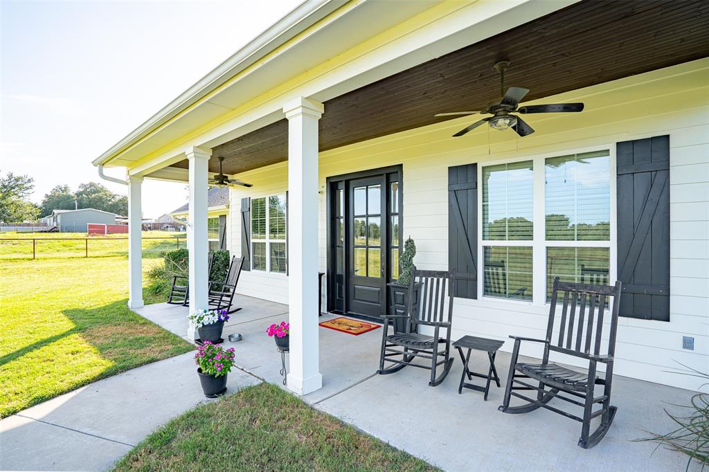 1920 Meander Road Granbury, TX 76049 - Photo 2 of 40 Front porch with white siding, black shutters, and a dark wood ceiling