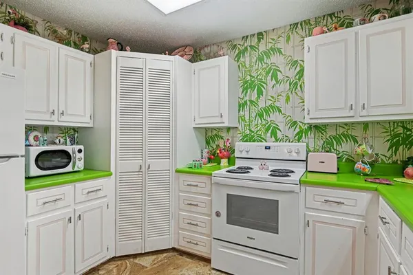 a kitchen with white cabinets and white appliances