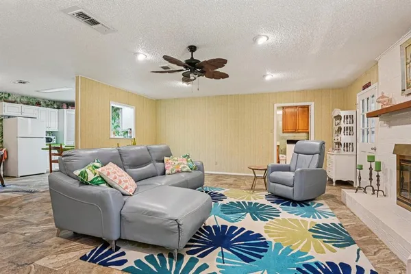 a living room with furniture and a view of kitchen