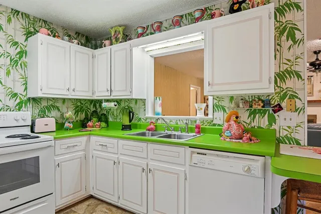 a kitchen with yellow cabinets and potted plant