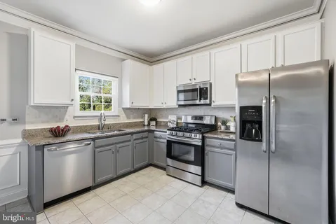 a kitchen with stainless steel appliances granite countertop a refrigerator sink and stove