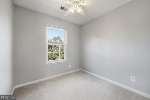 an empty room with a window and a fan